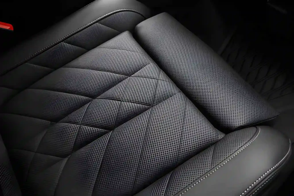 Close-up of clean, textured black leather seats, showcasing meticulous interior car detailing.