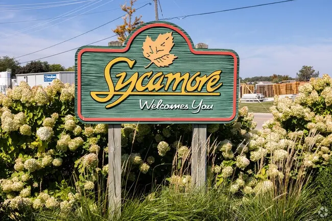 Sycamore Welcomes You city sign surrounded by white hydrangeas representing Pure Auto Care's local community in Sycamore IL